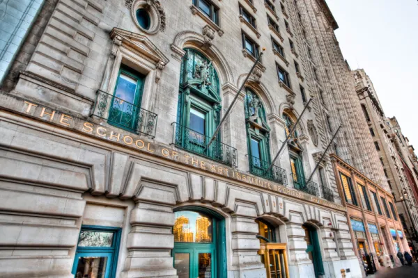 Stone building with oxodized copper features and title The School of the Art Institute across front. Photo Credit: Flickr