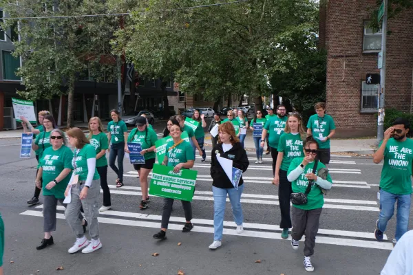 WFSE Higher Education members in green shirts walking with Walkout for Washington signs