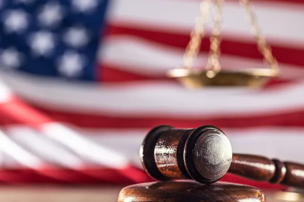 Photo of American flag in the background with a gavel in the foreground. Photo credit: Getty Images