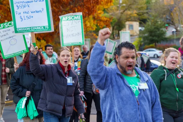 Photo of several AFSCME Oregon members with picket signs and marching for a fair contract