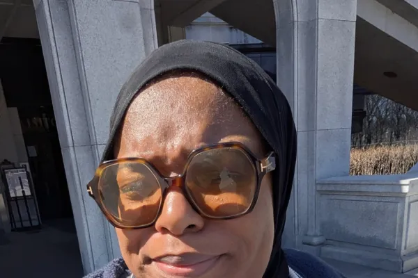 Selfie photo of a Black woman with a blue 1199 AFSCME shirt on
