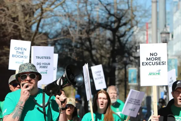 Photo of AFSCME WFSE members in green shirts holding picket signs saying No More Excuses!