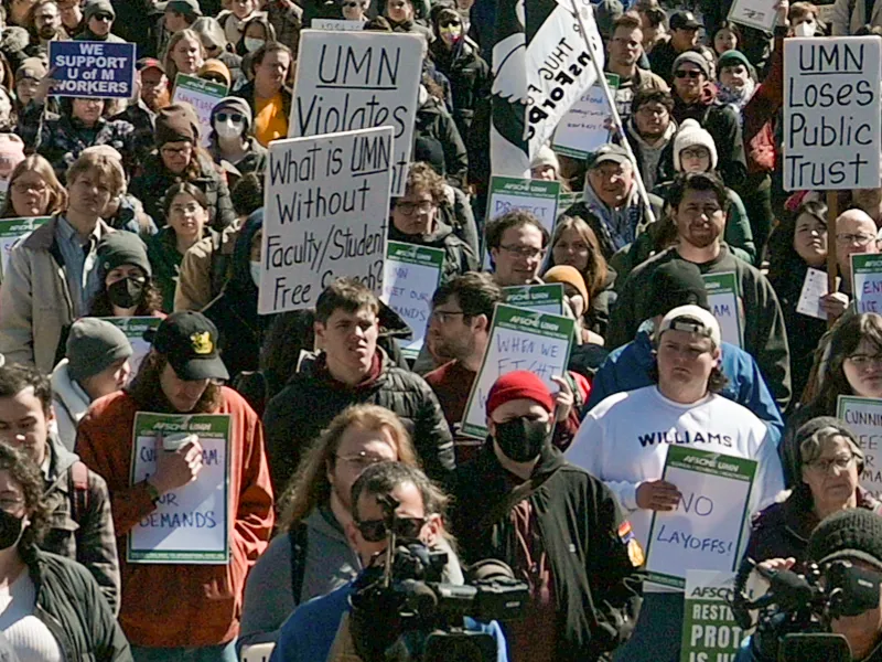 Many people at a rally holding signs at University of Minnesota rally