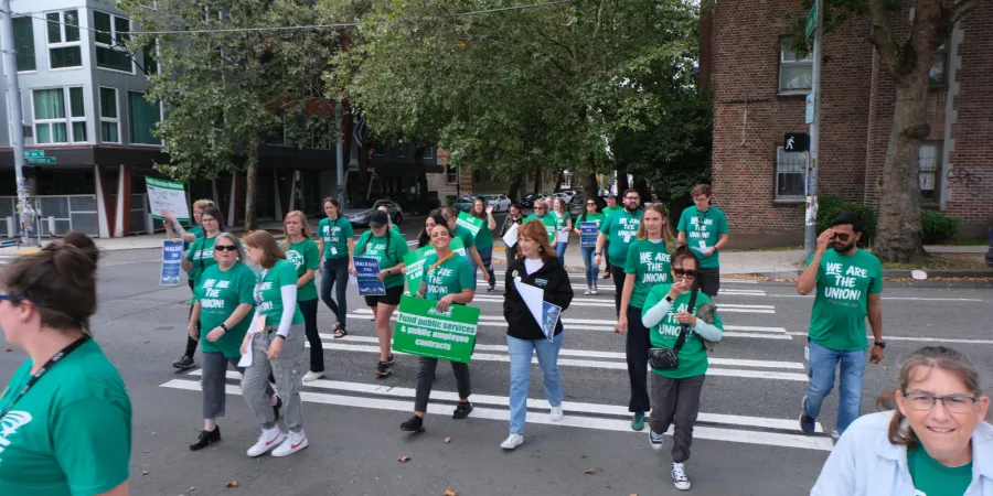 WFSE Higher Education members in green shirts walking with Walkout for Washington signs