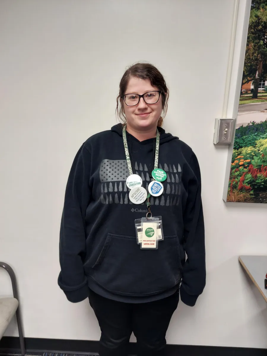 Photo of a white woman with dark hair and glasses smiling.