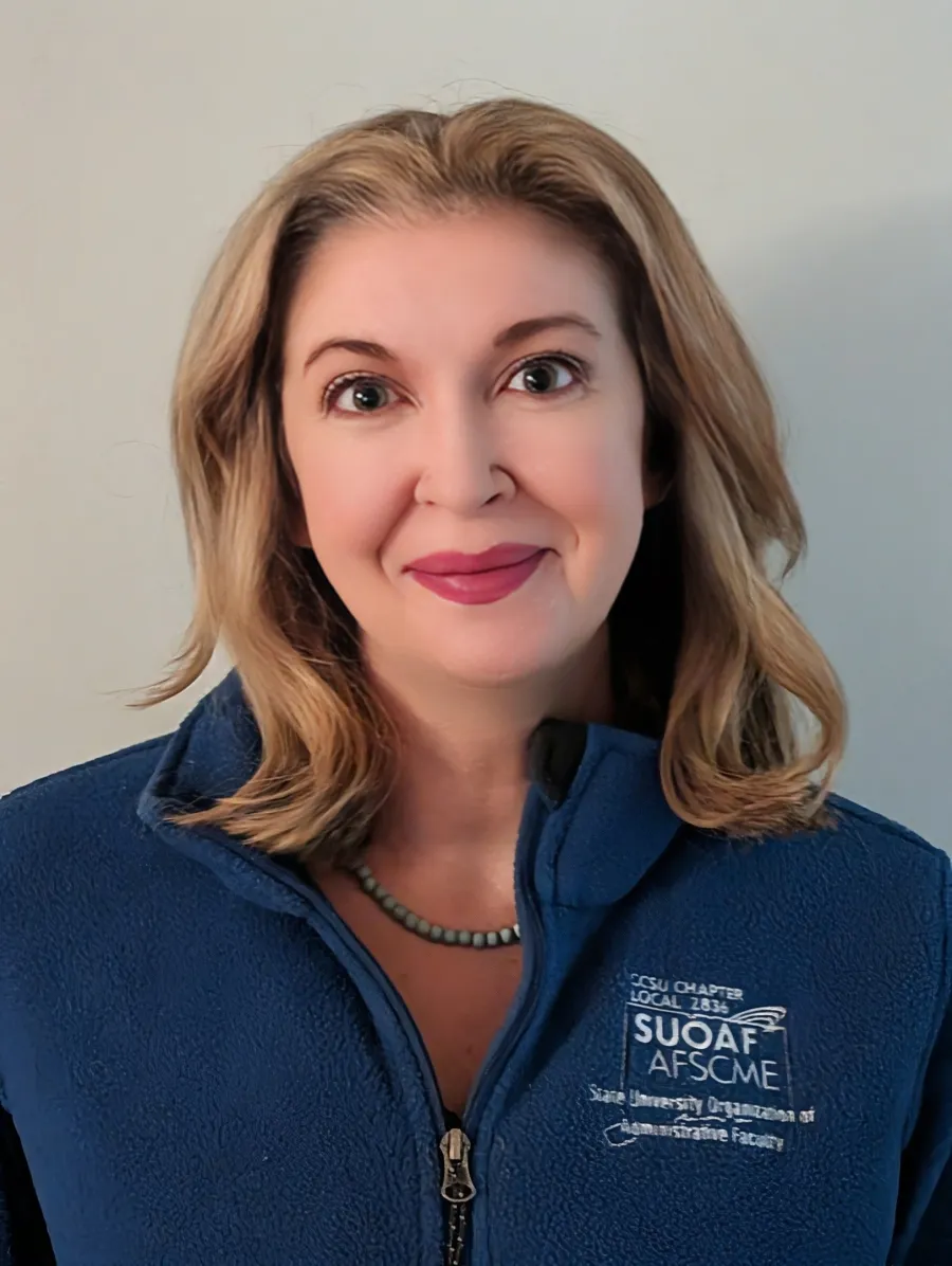 Photo of a white woman with shoulder length blonde hair wearing a blue AFSCME pullover