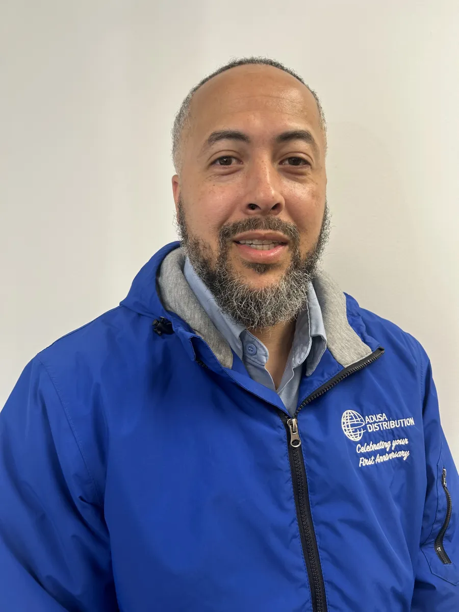 Photo of Black man with a beard and goatee in a blue jacket