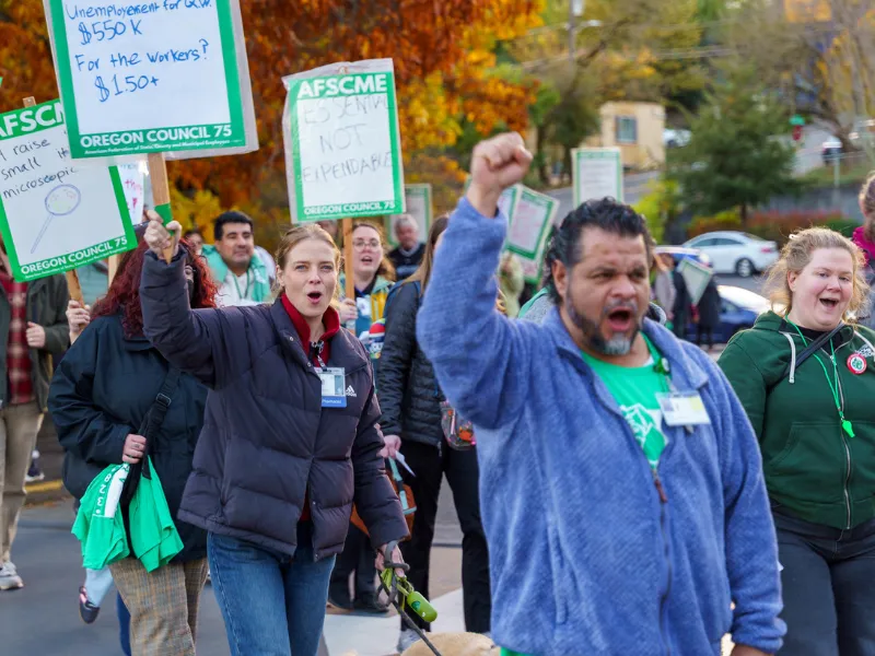 Photo of several AFSCME Oregon members with picket signs and marching for a fair contract