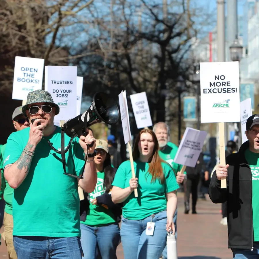 Photo of AFSCME WFSE members in green shirts holding picket signs saying No More Excuses!