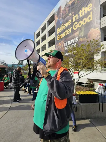 Photo of Aaron Metcalf holding a megaphone during the strike